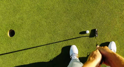 Top down view of golfer about to putt