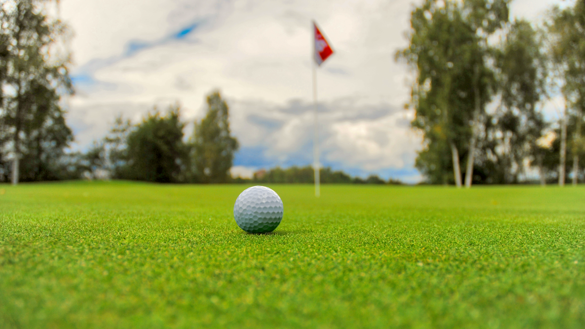 Golf ball on the greens with the hole in the background