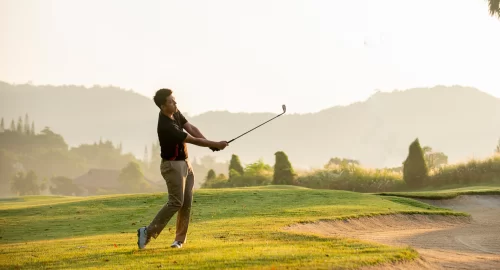 Golfer swinging his club on the golf course