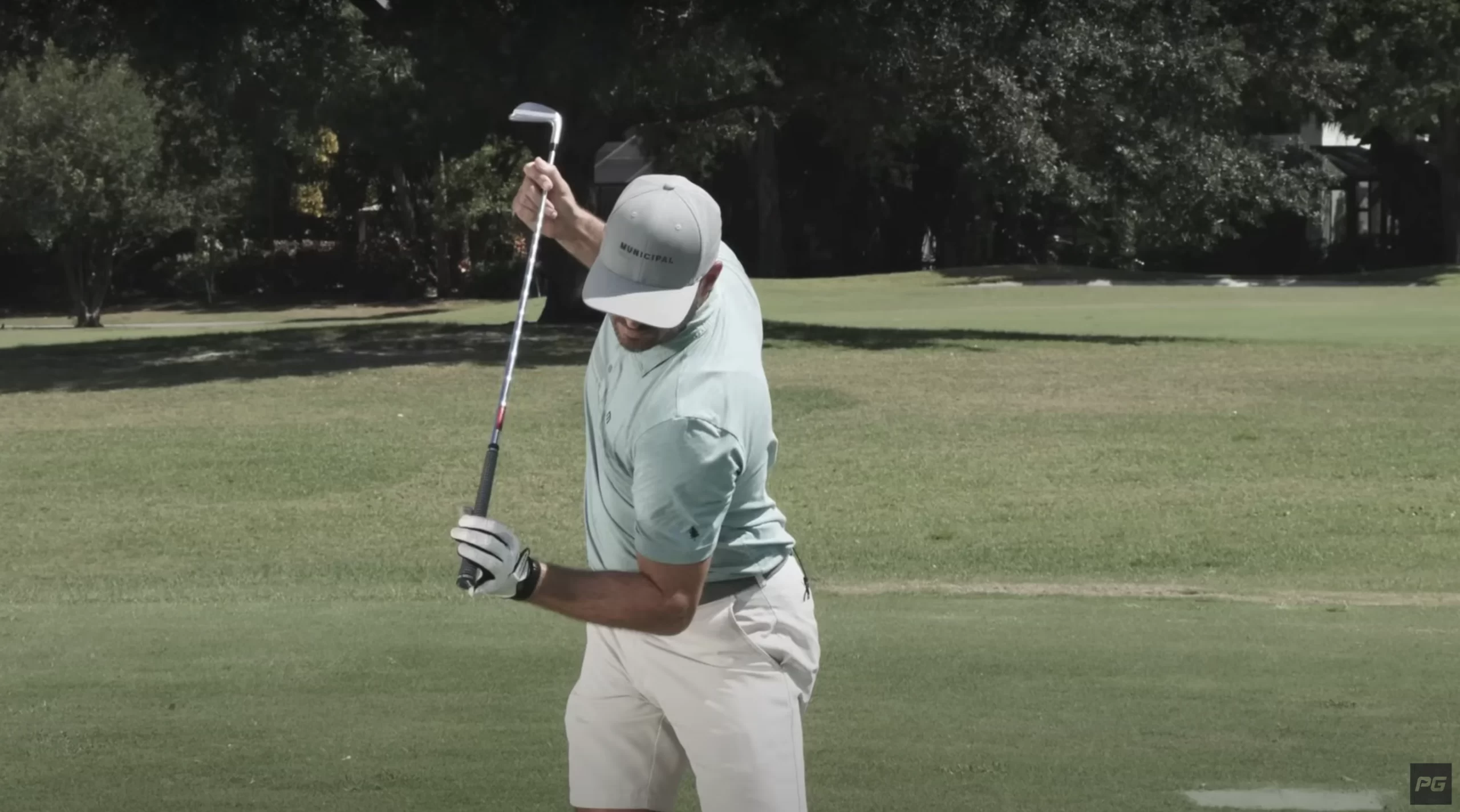 Photo of Performance Golf coach Eric Cogorno tilting his shoulders with the golf club being held up in front of his shoulders.